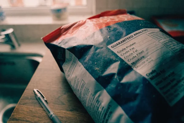 Dog food bag with guaranteed analysis label visible on a kitchen table
